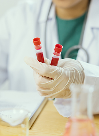 medical doctor holding blood sample and making notes writing on prescription